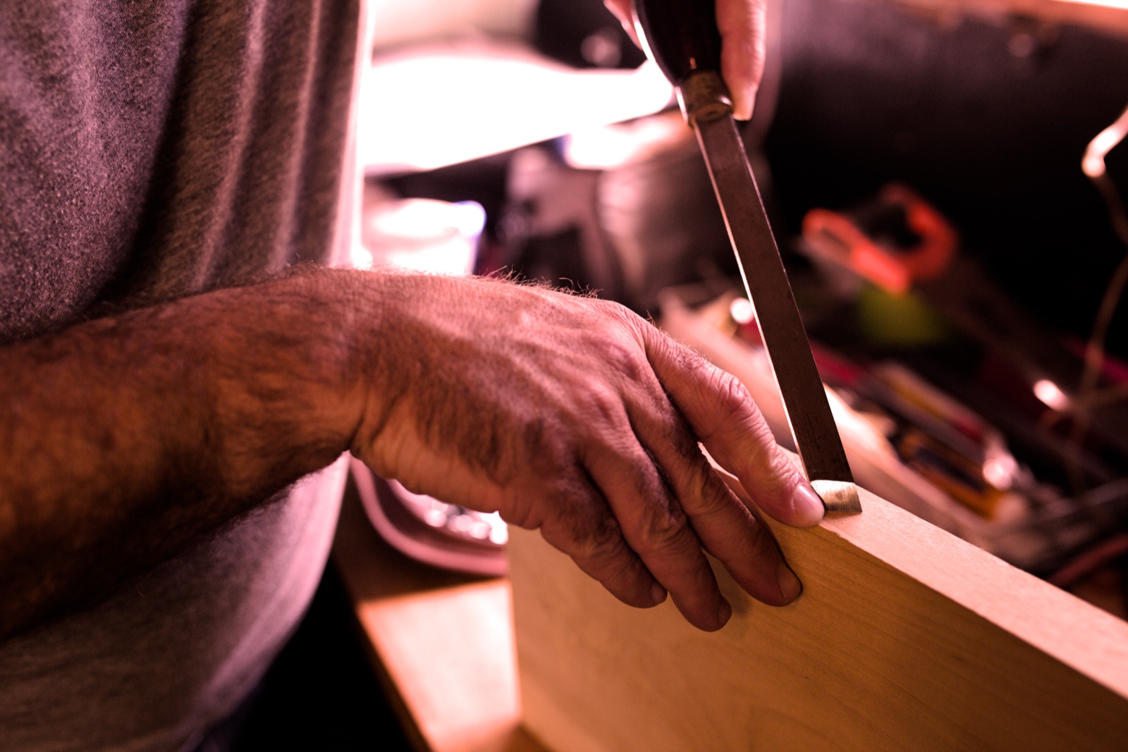 Grant hand-chiselling a hardwood stair component in the Niagara workshop